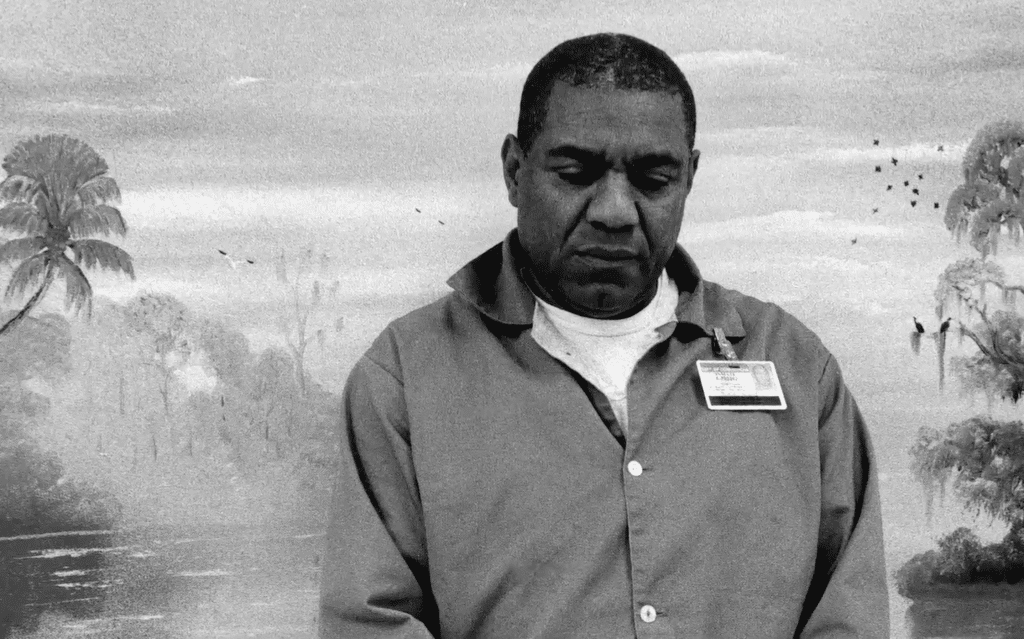 Al Black Highwaymen artist in front of a prison mural